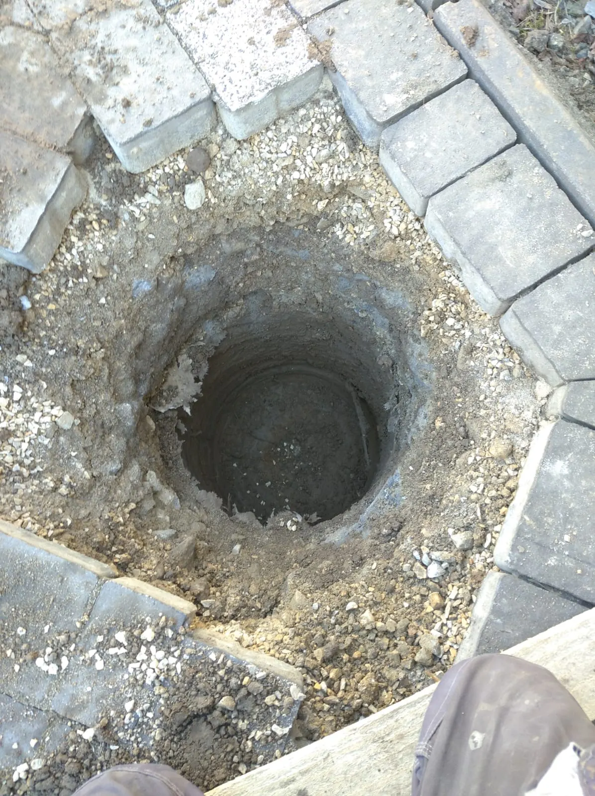 Otwór pod słupek fundamentowy wykonany w miejscu zdjętej kostki.
